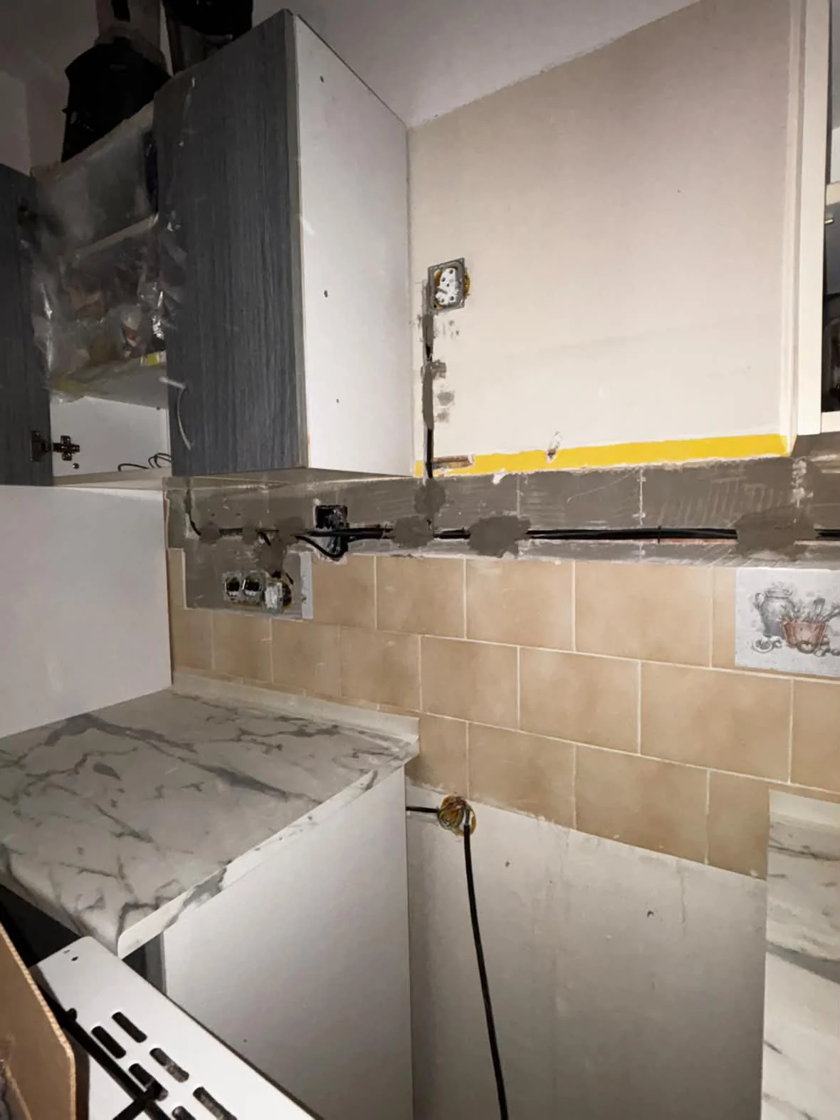 Rozpracované drážky a kabeláž ve stěně kuchyně během rekonstrukce
